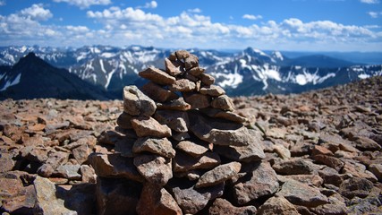 Mountain Rock Cairn with Blue Cloudy Sky