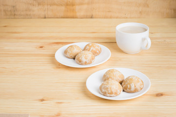 gingerbread on plates and  coffee wiht milk on a wooden background. breakfast or snack