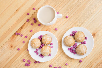 gingerbread on plates, coffee wiht milk and pink candy on a wooden background. breakfast or snack