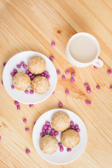 gingerbread on plates, coffee wiht milk and pink candy on a wooden background. breakfast or snack