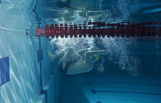 Man in swimming pool. Underwater