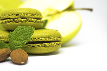 Obraz na płótnie Canvas French cookie macaroons with juicy green apple and mint leaves on white background