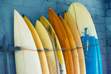 Set of different color surf boards in a stack by ocean.Bali,Indo