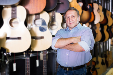 male is standing with modern guitar