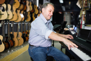 Smiling musician is playing on modern keyboard