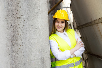 Confident young female architect standing arms crossed