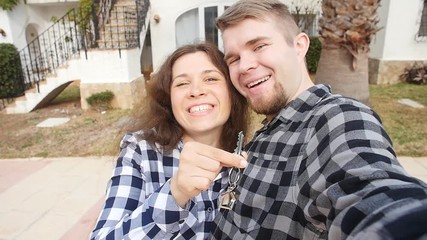 New homeowners with key selfie. Real estate, new house or apartment and people concept