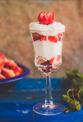Yogurt with strawberries in glass cup.
