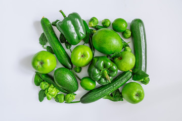 green vegetables and fruits on white background. overhead view