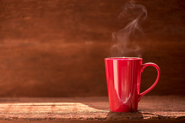 red coffee cup with smoke stream on wooden table under moring sunlight - Powered by Adobe