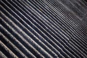 The texture of a voluminous slate on an old roof close up.