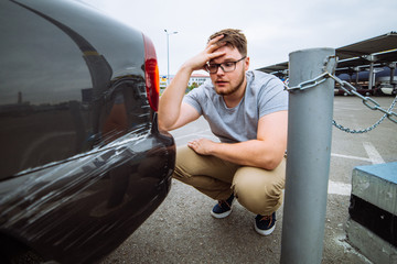 sad man sit near dint car with sad face. insurance case.