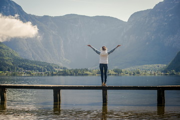 Woman hiker enjoys good weather. Physical activity in the journey. Young tourist woman on the bridge and enjoy the relaxation and freedom. Beautiful view of the mountain nature

