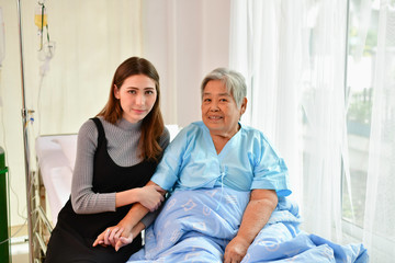 Obraz premium Patient Concept. Grandma's in the hospital. Waiting for someone to visit. Grandchildren visit grandma at the hospital. Grandma is happy to meet grandchildren.