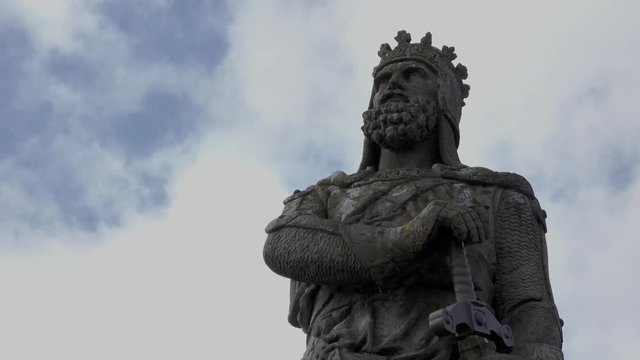 Fast motion clouds behind a statue of Robert the Bruce, Scottish king.