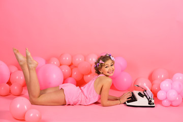 Obraz na płótnie Canvas Child in underwear with typewriter on pink background.