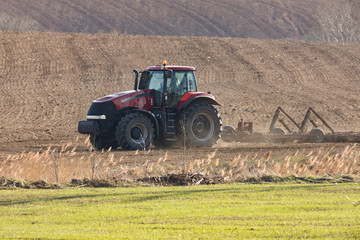 Obraz premium tractor harrowing on field