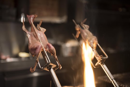 Chickens cooking over flame