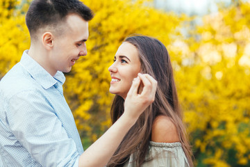 Young happy couple in love outdoors. Man and woman on a walk in a spring blooming park