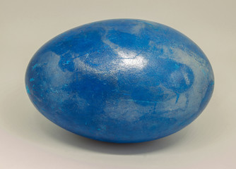 Theme Easter. Close-up of a duck egg colored in blue with pearl glitter.