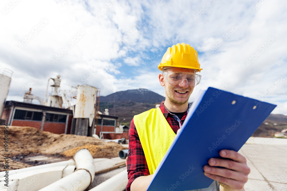 Wall mural Portrait of factory worker holding clipboard