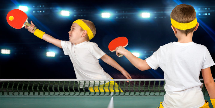  Two boys play ping-pong.