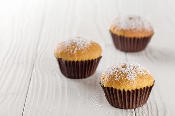 Classic muffins on a wooden old background in a brown paper.