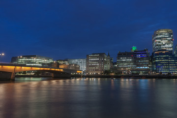 Thames embankment, London Bridge and london skyscrapers in City of London in the night.