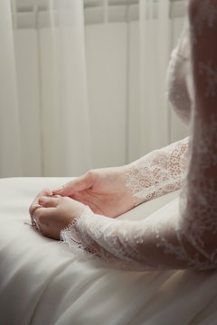 small naive cross in the bride's hands.  Bride worries on her wedding day. Solitude before the wedding