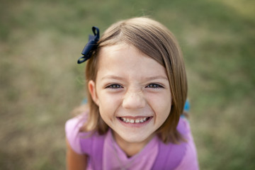 High angle portrait of smiling girl on grassy field