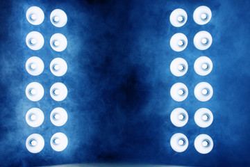 Dark room, between two powerful light columns and smoke