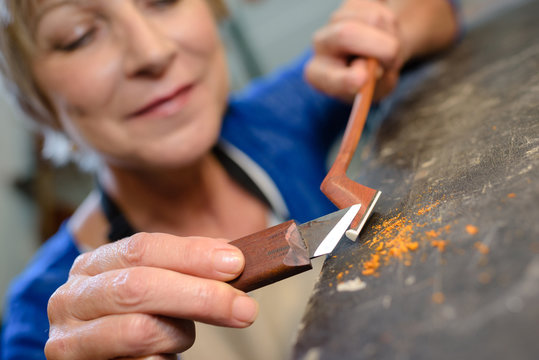 craftsman violin maker carving a bow in her workshop - Powered by Adobe