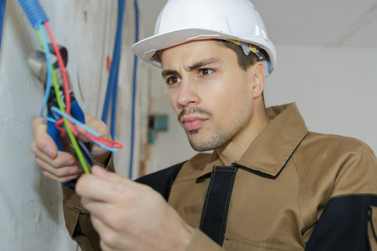 young electrician wiring in building