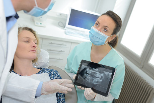 Dental assistant showing xray on tablet screen