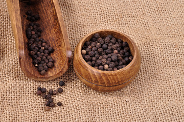 pepper not ground in a wooden bowl on a ragged background.