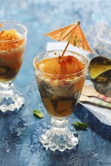 Homemade Mango Falooda topped with Tutti Frutti and cocktail Umbrella, selective focus