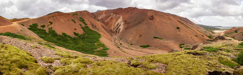 Wide angle panorama of red mountains of Lonsoraefi in Iceland
