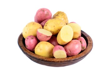 Raw potatoes in wooden bowl. Isolated close up food photo.
