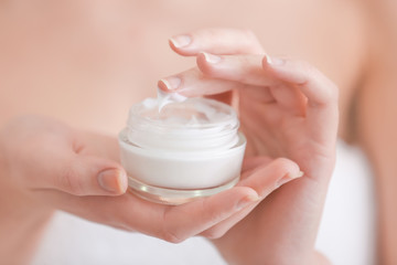 Young woman with jar of hand cream, closeup