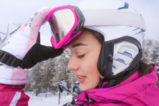 Young woman on ski piste at snowy resort. Winter vacation
