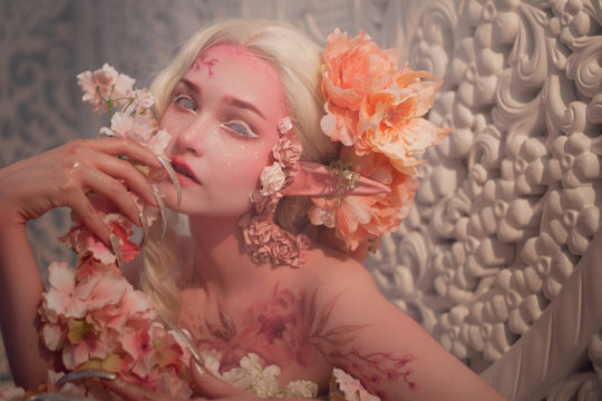 lovely she-elf among flowers. Creative make-up and bodyart