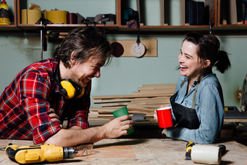 Carpenters having break from their work in wood workshop