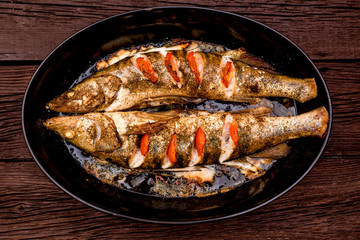 Top view zander fillet with tomatoes on frying pan