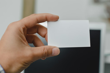 Obraz premium Close up on hand of a businessman showing business card office space background