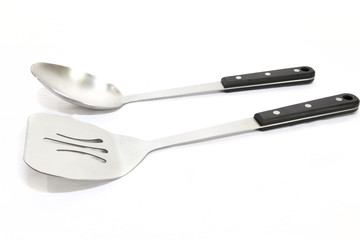 Large serving spoon and a spatula with black handles on a white bacground
