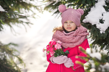 The baby in the winter woods and is holding a bouquet of flowers 935.