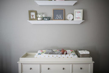 Newborn baby girl lying on changing table