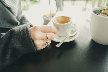 Human hand holding a cup of italian espresso coffee in a bar