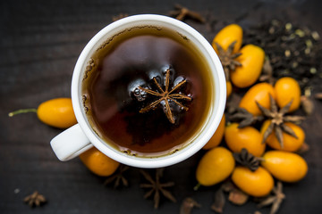Cup with tea kumquat baden aroma tea christmas kitchen table background