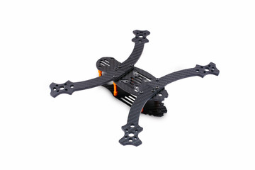 The beginning of the racing drone assembly. A robust frame of an unmanned aerial vehicle made of carbon fiber. Frame of carbon fiber quadrocopter isolated on white background